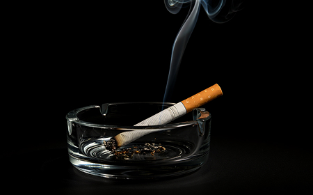 Макросъёмка горящей сигареты с клубами дыма